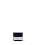 Black lip balm container with a white label on a white background